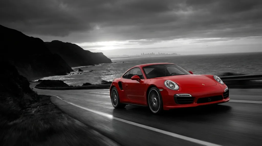 Monochrome Küstenstraße mit rotem Porsche 911 als Symbolbild für schwächere Porsche Auslieferungen